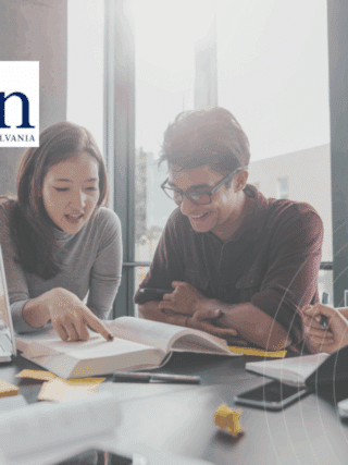 Groupe d’étudiants en pleine séance de travail collaboratif autour d’une table, avec ordinateurs portables et livres, dans une salle lumineuse de l’Université de Pennsylvanie (Penn), logo visible à l’arrière-plan.