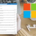 Capture d’écran d’une messagerie ouverte sur un ordinateur portable Windows, affichant une liste de courriels. À droite, le logo coloré de Microsoft est superposé sur un bureau en bois avec une tasse jaune, un crayon, des écouteurs sans fil et une plante verte en pot.