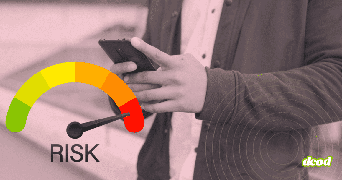 Personne tenant un smartphone entre les mains, vue cadrée au niveau du buste sans montrer le visage. À gauche, un cadran de risque en couleurs allant du vert au rouge affiche une aiguille pointant vers la zone de danger. À droite, des cercles concentriques évoquent une détection ou une analyse du signal. Le logo « dcod » apparaît en bas à droite.