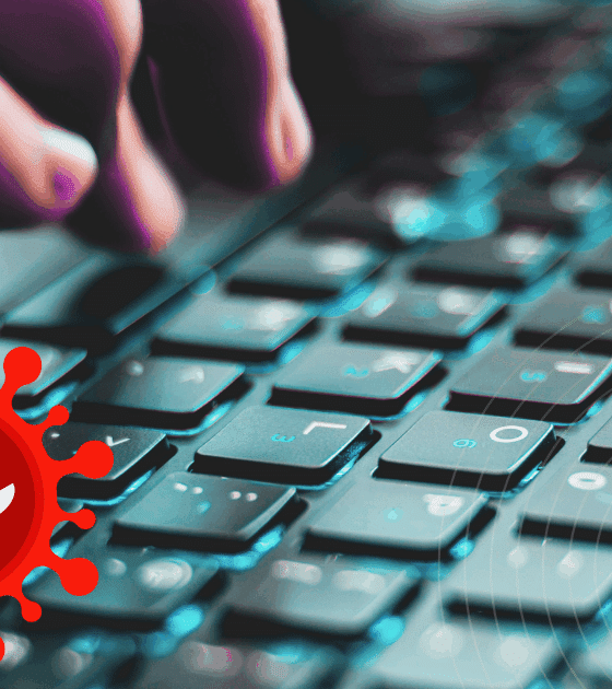 Gros plan sur une main tapant sur un clavier d’ordinateur, avec en surimpression une icône rouge représentant un virus informatique menaçant.