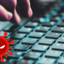 Gros plan sur une main tapant sur un clavier d’ordinateur, avec en surimpression une icône rouge représentant un virus informatique menaçant.