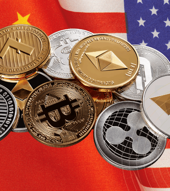 Un ensemble de pièces de cryptomonnaies posées à cheval entre les drapeaux de la Chine et des États-Unis, symbolisant des enjeux financiers et technologiques.