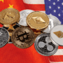 Un ensemble de pièces de cryptomonnaies posées à cheval entre les drapeaux de la Chine et des États-Unis, symbolisant des enjeux financiers et technologiques.