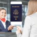 Une agente d’enregistrement reçoit un document d’identité tandis qu’un passeport numérique apparaît en surimpression au-dessus de la scène.