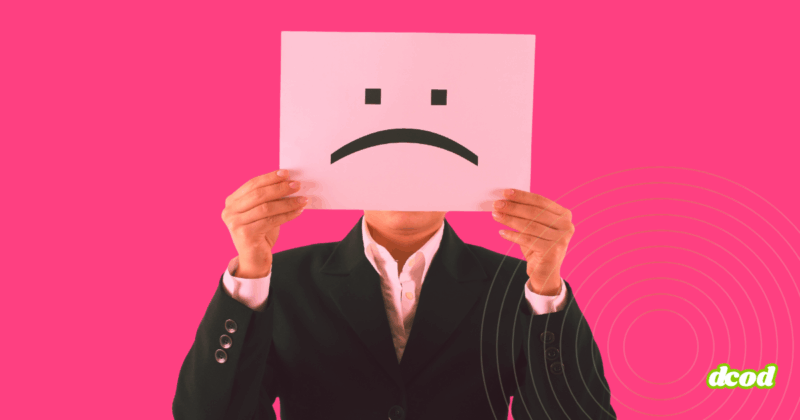 Une personne en costume tenant devant son visage une feuille avec un visage triste, symbolisant une potentielle menace interne en entreprise.