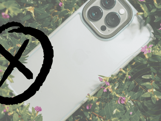 Un smartphone clair partiellement entouré de plantes, recouvert d’un large symbole noir en forme de cercle barré.