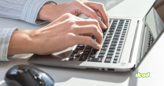 Gros plan sur des mains utilisant un ordinateur portable sur un bureau, illustrant un usage professionnel quotidien et la dépendance croissante au poste de travail numérique.
