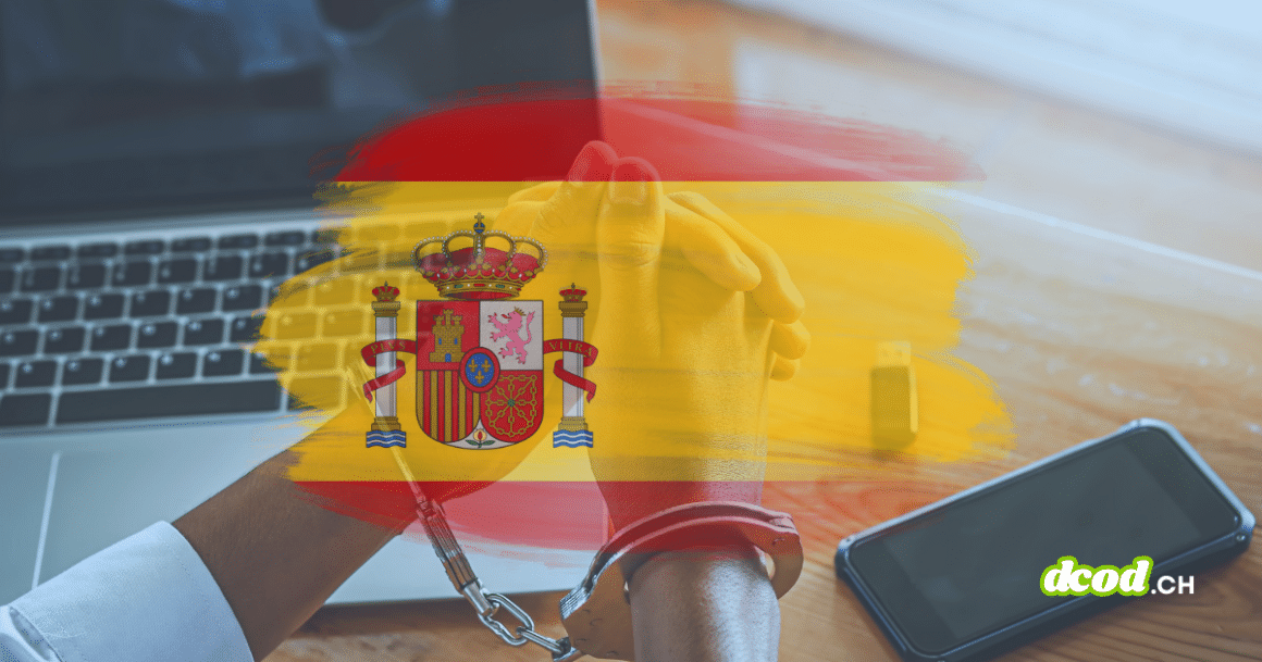 Mains menottées devant un ordinateur portable, avec drapeau espagnol en surimpression et smartphone sur la table.