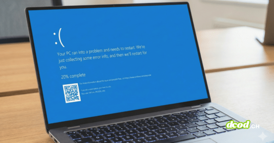 Gros plan sur un ordinateur portable argenté ouvert, posé sur un bureau en bois. L'écran affiche le message d'erreur "écran bleu" de Windows 10/11 avec un grand émoticône triste ":(", le texte "Votre PC a rencontré un problème et doit redémarrer", une progression indiquant "20% effectués", un QR code pour plus d'informations et le code d'arrêt spécifique "CRITICAL_PROCESS_DIED". Le clavier rétroéclairé est visible et l'arrière-plan du bureau est flou.