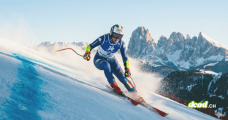 Photographie d'une skieuse alpine italienne en pleine action lors d'une descente de slalom géant, portant le dossard de Milan Cortina 2026, avec les montagnes des Dolomites en arrière-plan.