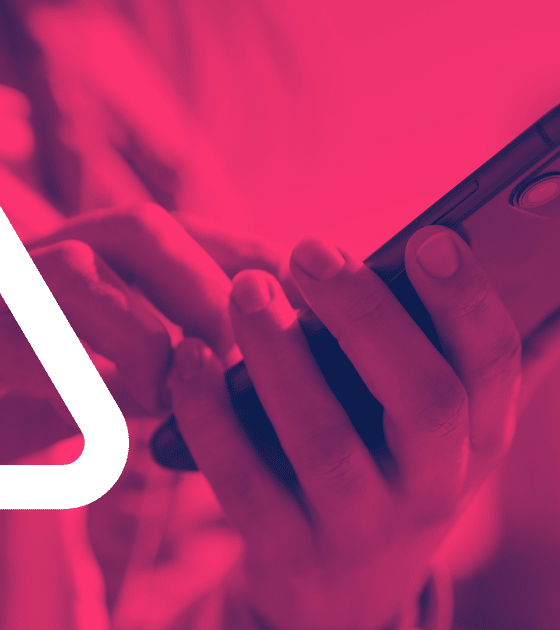 Image d'alerte urgente : un grand triangle d'avertissement blanc est superposé sur une photo d'un iPhone tenu en main. Le filtre rouge vif et l'icône signalent la vulnérabilité critique DarkSword. Le logo dcod.ch est présent dans le coin inférieur droit.