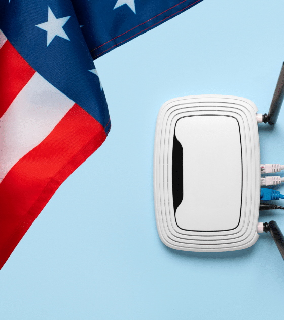 Illustration de la décision de la FCC : un routeur Wi-Fi blanc branché à côté du drapeau américain, symbolisant les routeurs étrangers bannis pour protéger la sécurité des réseaux US (logo DCOD).