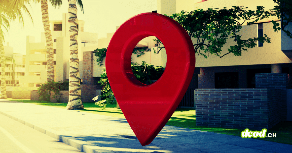 Une grande épingle de géolocalisation rouge posée sur un trottoir devant des bâtiments modernes et des palmiers, illustrant le traçage géographique et la surveillance.