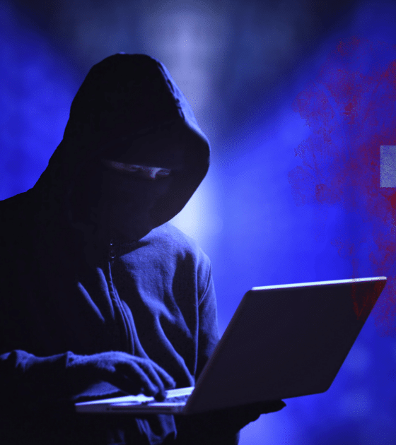 Silhouette de hacker en sweat à capuche noir utilisant un ordinateur portable devant un fond bleu numérique, avec le drapeau suisse stylisé en arrière-plan.