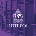 Illustration d'une salle de serveurs informatiques avec le logo d'Interpol en blanc sur un filtre violet, symbolisant le démantèlement d'infrastructures cybercriminelles lors de l'opération Synergia III.