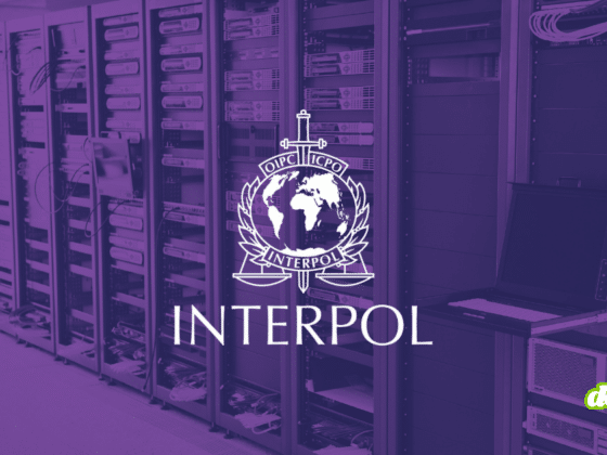 Illustration d'une salle de serveurs informatiques avec le logo d'Interpol en blanc sur un filtre violet, symbolisant le démantèlement d'infrastructures cybercriminelles lors de l'opération Synergia III.