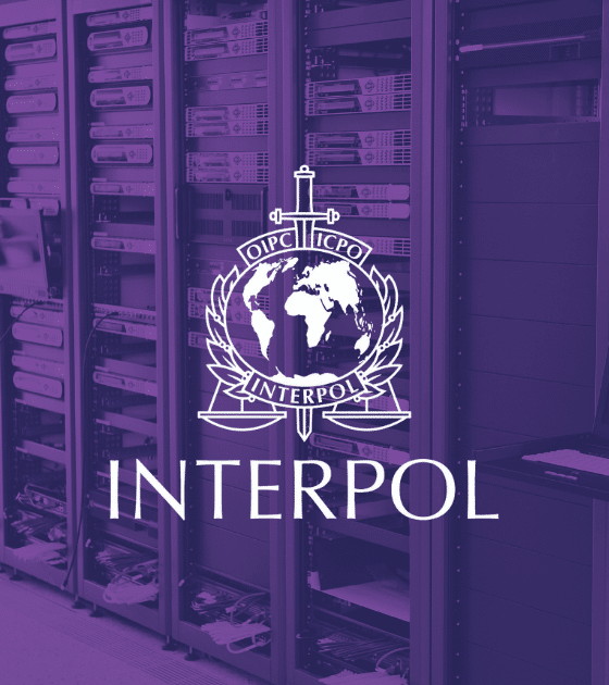 Illustration d'une salle de serveurs informatiques avec le logo d'Interpol en blanc sur un filtre violet, symbolisant le démantèlement d'infrastructures cybercriminelles lors de l'opération Synergia III.