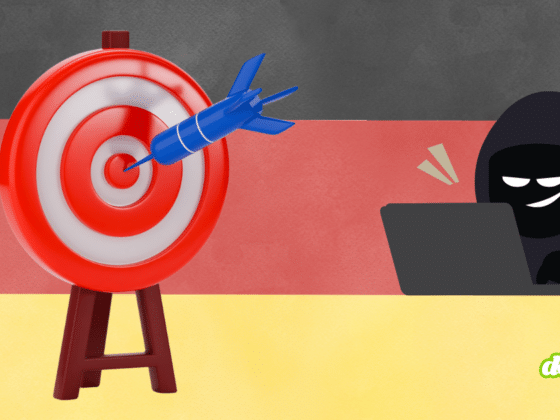 Illustration symbolique représentant un pirate informatique masqué derrière un ordinateur ciblant le drapeau allemand avec une fléchette. L'Allemagne devient la cible numéro 1 de la cyber-extorsion en Europe.