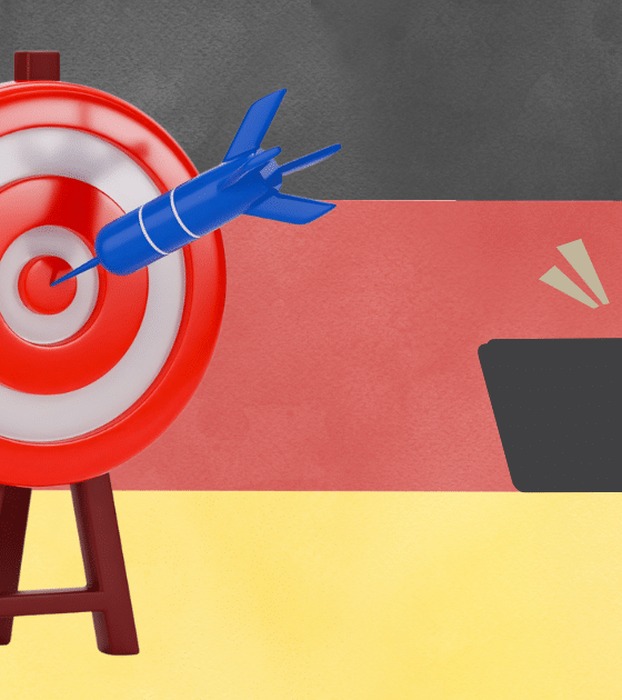 Illustration symbolique représentant un pirate informatique masqué derrière un ordinateur ciblant le drapeau allemand avec une fléchette. L'Allemagne devient la cible numéro 1 de la cyber-extorsion en Europe.