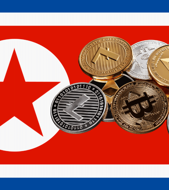 Illustration montrant le drapeau de la Corée du Nord superposé à un tas de pièces de cryptomonnaies (Bitcoin, Ethereum, XRP, Litecoin), symbolisant le vol de 285 millions de dollars au protocole Drift par un groupe nord-coréen.