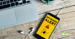 Illustration d'un smartphone iOS affichant un message de sécurité "Spyware Alert" avec une icône d'araignée sur un bureau en bois, symbolisant l'alerte de WhatsApp concernant les 200 victimes d'un spyware italien infiltré via une fausse application.