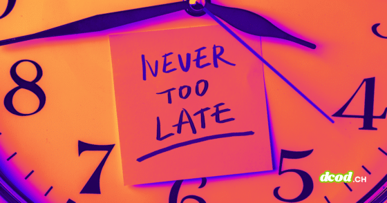 Image d'illustration sur l'urgence cyber : Gros plan en tons chauds sur un cadran d'horloge. Au centre, une note adhésive porte l'inscription manuscrite "NEVER TOO LATE", soulignant la nécessité pour le NIST de trier les vulnérabilités pour éviter le chaos. Le logo DCOD.ch est visible dans le coin inférieur droit.