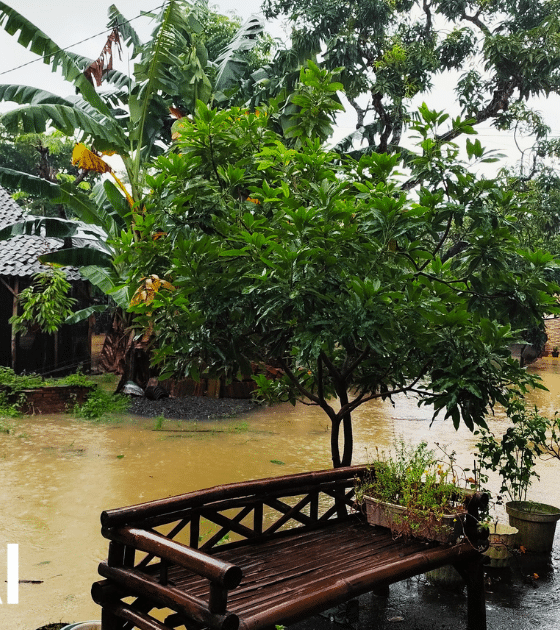 Quartier résidentiel inondé en Asie avec le logo OpenAI, illustrant comment l'entreprise déploie l'IA pour optimiser la gestion des catastrophes naturelles.