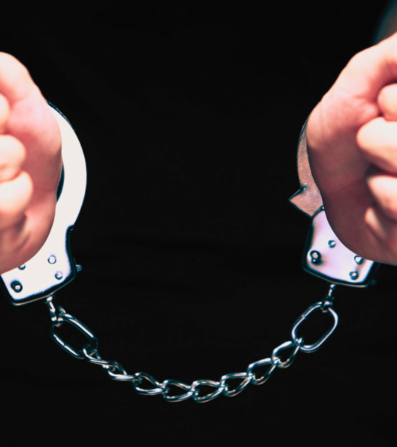Illustration de mains menottées symbolisant l'identification par les autorités d'Allemagne des chefs des réseaux de ransomware REvil et GandCrab.