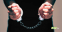 Illustration de mains menottées symbolisant l'identification par les autorités d'Allemagne des chefs des réseaux de ransomware REvil et GandCrab.