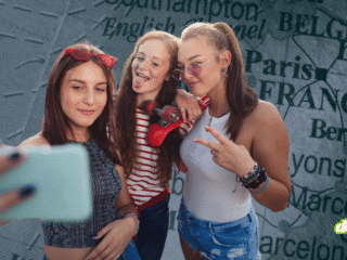 Trois jeunes personnes prenant un selfie devant une carte de l'Europe pour illustrer les enjeux de la vérification d'âge de l'UE et la découverte d'une faille critique.