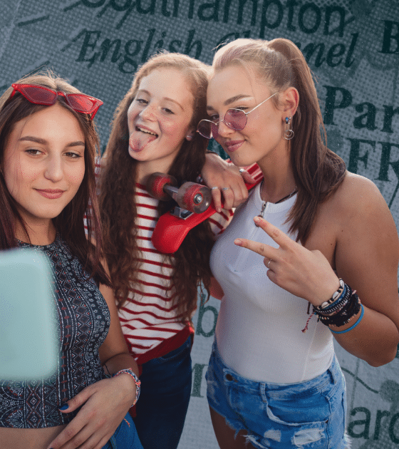 Trois jeunes personnes prenant un selfie devant une carte de l'Europe pour illustrer les enjeux de la vérification d'âge de l'UE et la découverte d'une faille critique.