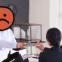 Illustration pour l'alerte du FBI sur les intrusions physiques dans les bureaux : un individu suspect au visage masqué par un émoji orange se présente à l'accueil d'une entreprise pour usurper l'identité d'un technicien.