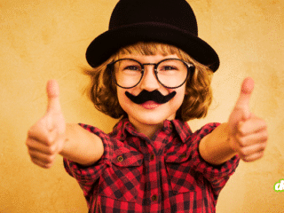 Enfant portant une fausse moustache et un chapeau melon pour illustrer la facilité de tromper une IA de vérification d'âge avec des accessoires rudimentaires.