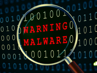 Une loupe examine du code binaire et révèle l'alerte rouge "WARNING MALWARE", illustrant les cyberattaques visant la chaîne de production logicielle où la confiance devient une arme.