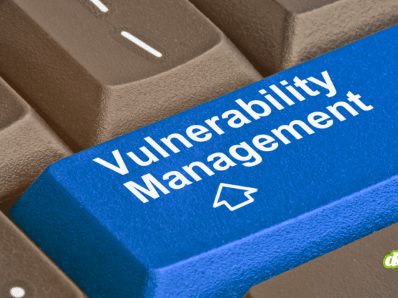 Gros plan sur un clavier d'ordinateur où la touche Entrée, de couleur bleue et marquée du logo d'un média tech, affiche l'inscription en blanc Vulnerability Management pour illustrer la divulgation de failles par un chercheur face à Microsoft.