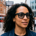 Gros plan d'une femme portant les lunettes connectées META Ray-Ban dans une rue animée.