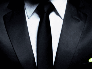 Gros plan d'un costume élégant et d'une cravate noire, illustrant l'ascension du ransomware The Gentlemen qui bouscule le marché du cybercrime avec son split de rançon inédit à 90%.