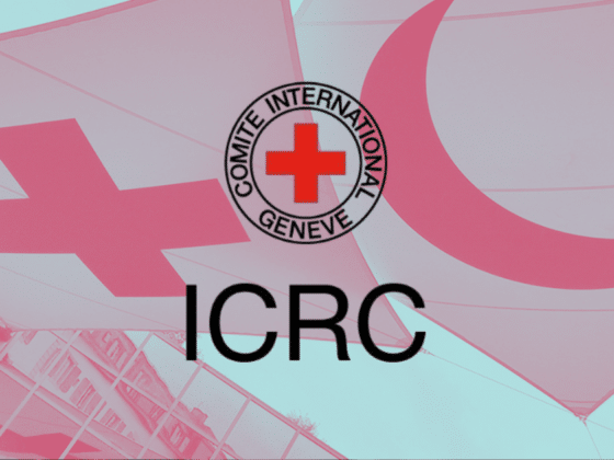 Logo officiel du CICR en noir avec sa croix rouge, superposé sur les drapeaux de la Croix-Rouge et du Croissant-Rouge sur fond turquoise. Ce visuel symbolise la transition historique alors que le CICR adopte l'emblème numérique ADEM contre les cyberattaques.