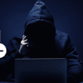 Silhouette de hacker en sweat à capuche devant un ordinateur, surmontée d'icônes de calendrier et d'horloge illustrant que les cybercriminels spécialisés dans les ransomwares suivent des horaires de bureau.