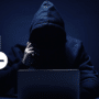 Silhouette de hacker en sweat à capuche devant un ordinateur, surmontée d'icônes de calendrier et d'horloge illustrant que les cybercriminels spécialisés dans les ransomwares suivent des horaires de bureau.