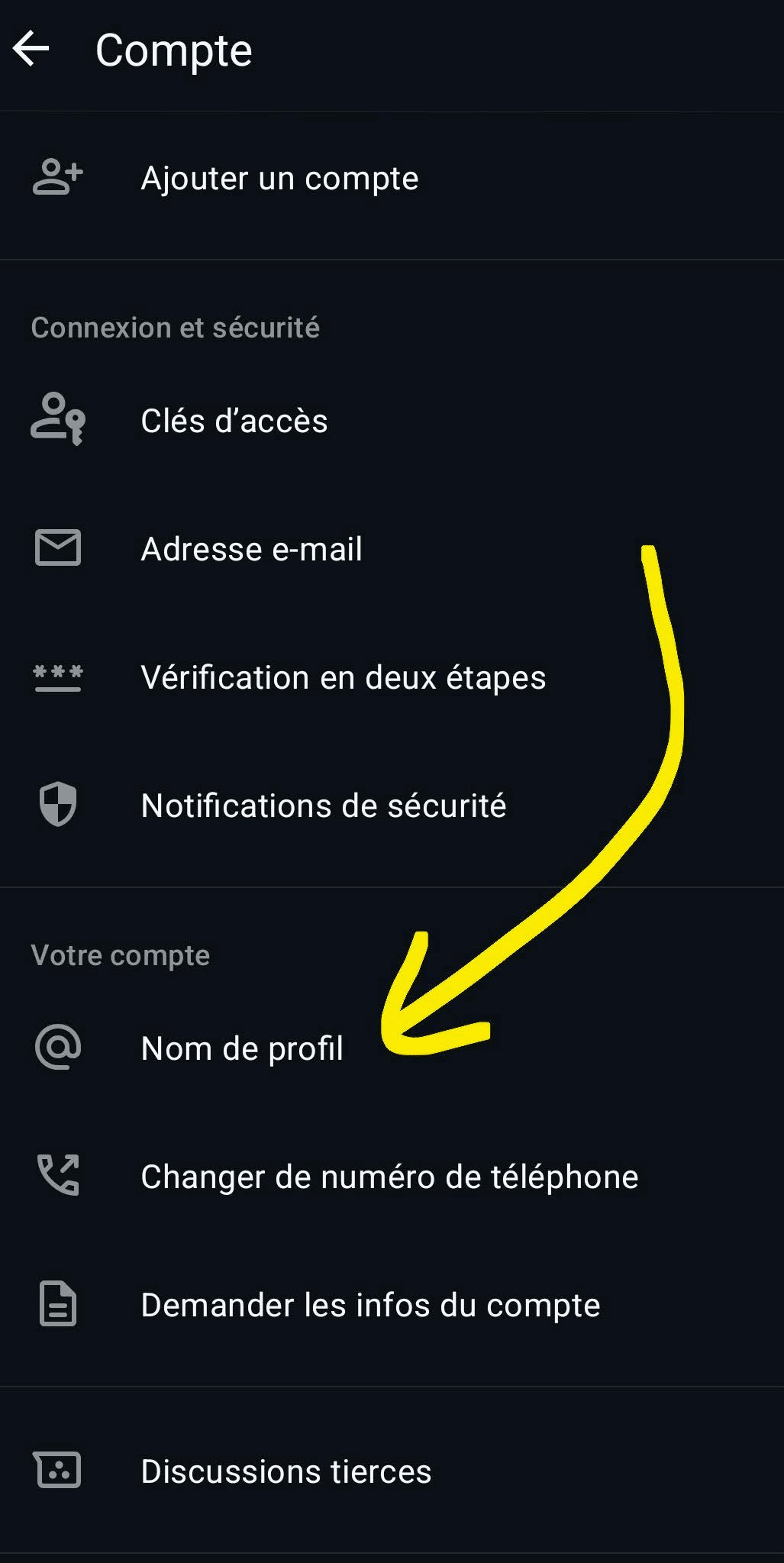 Capture d'écran du menu de configuration Compte sur l'application WhatsApp en mode sombre, où une flèche jaune dessinée à la main pointe vers l'option nommée Nom de profil.
