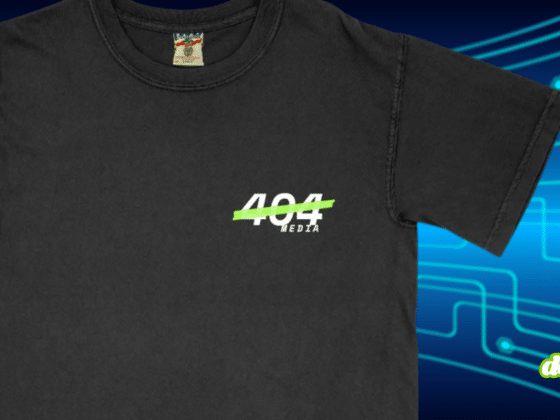 T-shirt noir floqué du logo de 404 Media sur la poitrine, sur un fond bleu à motifs de circuits électroniques.