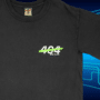 T-shirt noir floqué du logo de 404 Media sur la poitrine, sur un fond bleu à motifs de circuits électroniques.