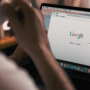 Personne sur un ordinateur portable consultant le navigateur Google Chrome, illustrant comment Google Chrome corrige plus de 1 000 vulnérabilités de sécurité grâce à l'IA.