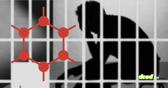 Logo rouge de GrapheneOS devant la silhouette d'un utilisateur derrière des barreaux de prison, illustrant les poursuites de la justice américaine.