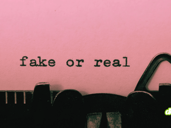 Gros plan sur une machine à écrire affichant les mots "fake or real" dactylographiés sur une feuille rose.