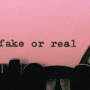 Gros plan sur une machine à écrire affichant les mots "fake or real" dactylographiés sur une feuille rose.