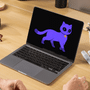 Un utilisateur assis à un bureau en bois consulte sur son ordinateur portable l'assistant Lumo de Proton, symbolisé par un chat violet à l'écran, illustrant l'outil AI Paper Trail conçu pour évaluer la confidentialité des échanges sur ChatGPT et Claude. — Logo DCOD en filigrane.