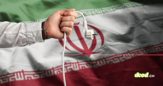 Texte alternatif (alt) : Une main débranche une prise électrique sur fond du drapeau de l'Iran, illustrant la cyberattaque contre une centrale électrique au Royaume-Uni.