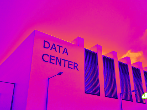 Façade moderne d'un centre de données sous un ciel aux teintes violettes et orangées, illustrant les infrastructures cloud.